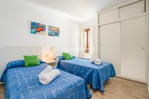 アレナル・デン・カステルにあるApartamento TORRALBA 4の青いシーツ、緑の枕が備わる客室のベッド2台