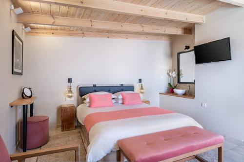 a bedroom with a large bed with pink pillows at Viaggio Elegant Rooms in Chania Town