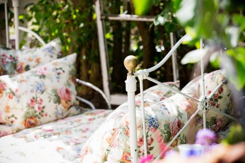 a white bed with floral pillows on it at Strandflickornas Annex Gula Villan in Lysekil
