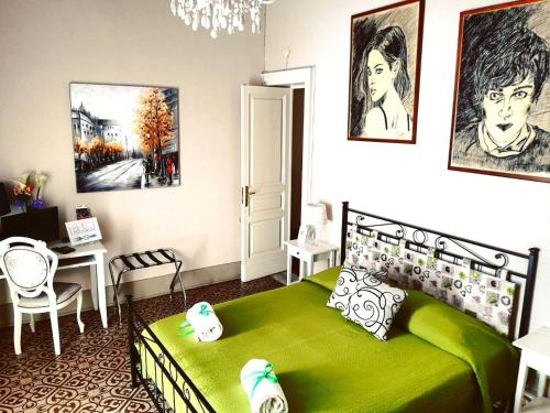 a bedroom with a green bed and a desk at Casa Elide in Catania