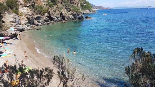a group of people in the water at a beach at Casa Porticciolo in Rio Marina