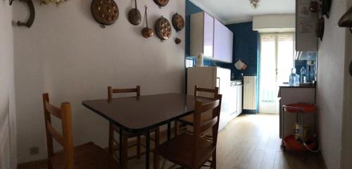 a kitchen with a table and chairs and a refrigerator at A bright central flat at Limone Piemonte in Limone Piemonte