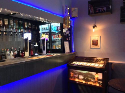 um bar com luzes azuis na parede em Brene Hotel em Blackpool