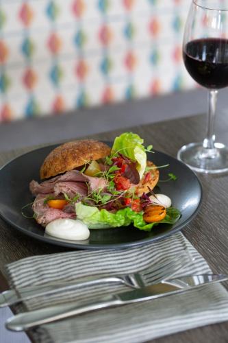 a black plate with a sandwich and a glass of wine at Hogarths in Solihull