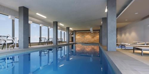 a swimming pool with tables and chairs in a building at Dakota Dunes Resort in Dundurn