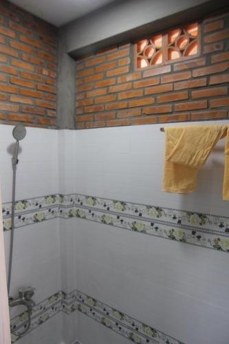 a bathroom with a brick wall and a bath tub at Bầu Bí Mini Farmstay Mekong - Tiền Giang in My Tho