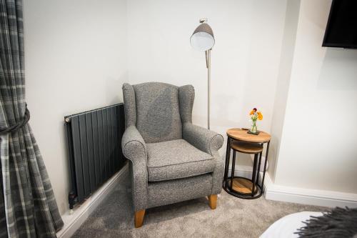 a chair sitting next to a lamp in a room at Alpaca Fold in Preston