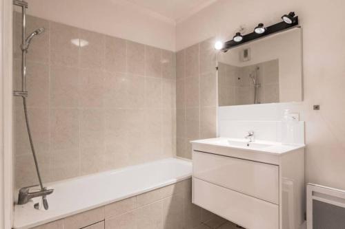 une salle de bain avec une baignoire, un lavabo et une douche dans l'établissement Prague apartment in Disneyland, à Montévrain