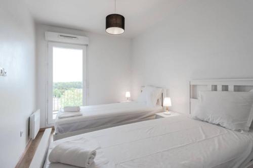 une chambre blanche avec deux lits et une fenêtre dans l'établissement Prague apartment in Disneyland, à Montévrain