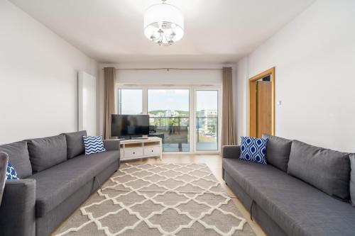 un soggiorno con divano e TV di Family Holiday Apartment Aquamarina Prima by Renters a Międzyzdroje