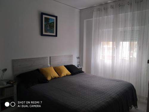 - une chambre avec un lit doté d'oreillers jaunes et d'une fenêtre dans l'établissement Anacasa Hipocampo Les Marines AP2133, à Dénia