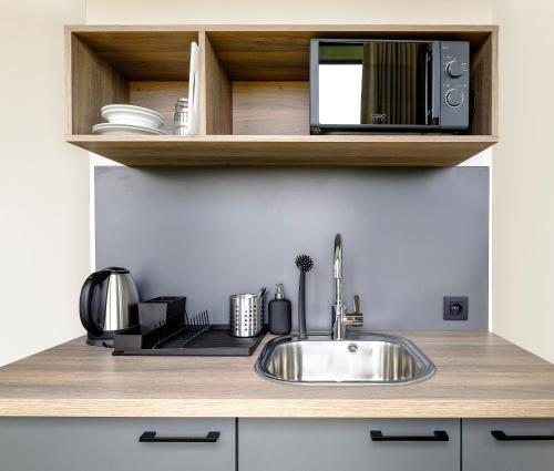 a kitchen counter with a sink and a microwave at Go Hotel City Apartments in Copenhagen