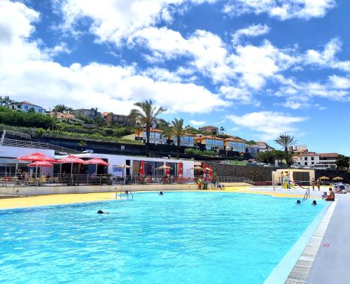 a large swimming pool with people in the water at Madeira Offline by Amazing Madeira in Ponta Delgada
