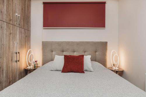 a bedroom with a large bed with a red pillow at Casaelia in Zakynthos Town
