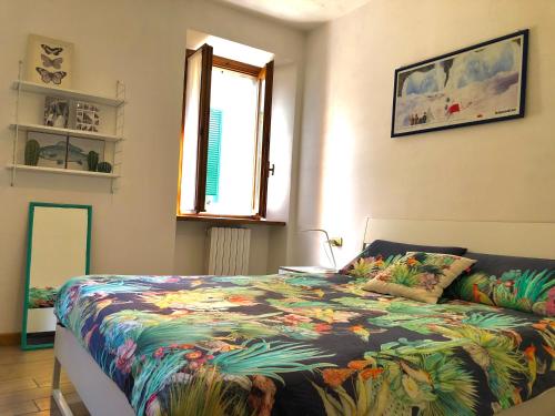a bedroom with a bed with a colorful blanket at Casa Eugenia in Argegno