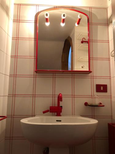 La salle de bains est pourvue d'un lavabo blanc et d'un miroir. dans l'établissement Casa Eugenia, à Argegno