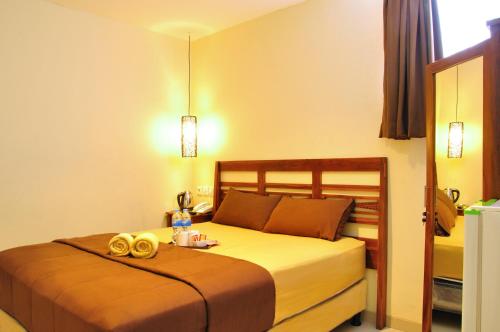 a hotel room with a bed with two gold rings at Kuta Sari House in Kuta