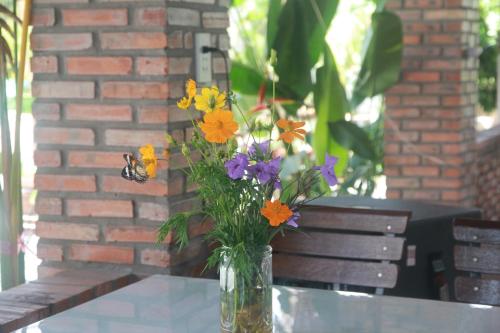 a vase filled with flowers sitting on a table at Bầu Bí Mini Farmstay Mekong - Tiền Giang in My Tho