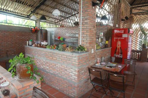 a brick wall with a bar in a restaurant at Bầu Bí Mini Farmstay Mekong - Tiền Giang in My Tho