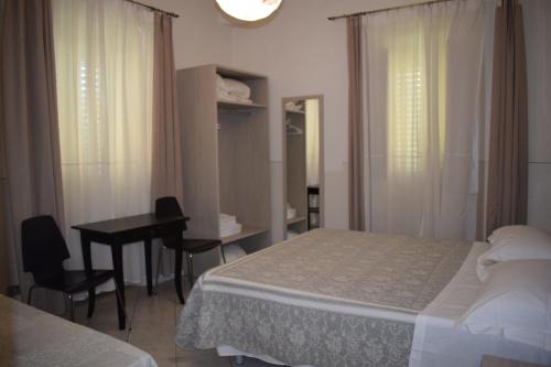 a bedroom with a bed and a table and a desk at Soggiorno Santa Reparata in Florence