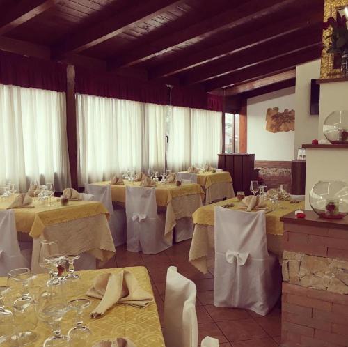 a large room with tables with white tablesearcher at Hotel PINO LORICATO in Castelluccio Inferiore