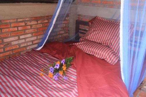 a bed with flowers and a pillow on it at Bầu Bí Mini Farmstay Mekong - Tiền Giang in My Tho