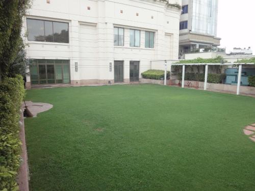 a large yard of green grass in front of a building at Radisson Hotel Varanasi in Varanasi