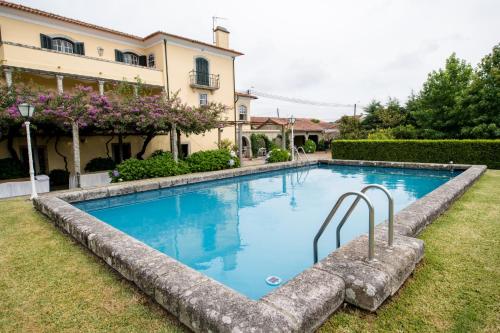 una piscina en un patio junto a una casa en Casa de São João en Viana do Castelo