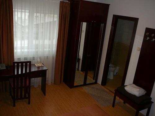 a room with a table and a chair and a mirror at Casa iRMA - Rooms for rent in Bacău