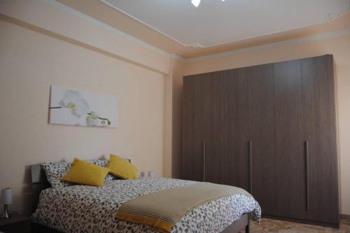 Eloisa Guest House في شاكا: غرفة نوم بسرير كبير مع مخدات صفراء