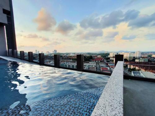 uma piscina no topo de um edifício com uma cidade em Imperio Residence Bathtub Studio Melacca Town-FreeParking em Malaca