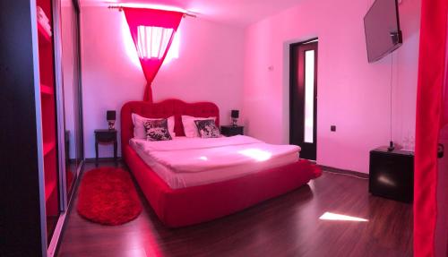 a pink bedroom with a bed with a red light at Casa B&D Residence in Deva