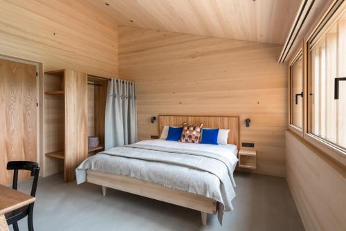 a bedroom with a bed and a wooden wall at Fuchsegg Eco Lodge in Egg