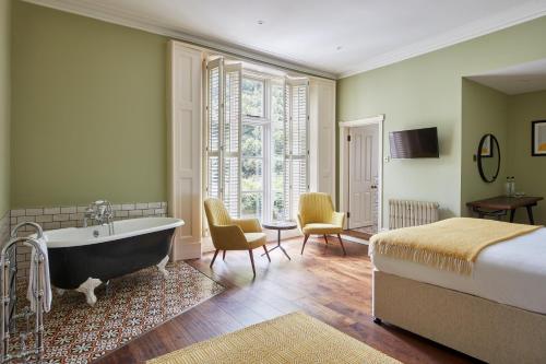 a bedroom with a bed and a tub in a room at The Priory Hotel in Newport