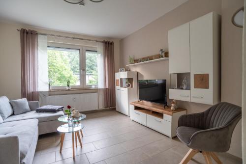 a living room with a couch and a tv at Heimathafen in Bremerhaven