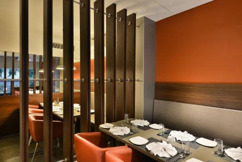 une salle à manger avec une table et des chaises ainsi qu'un restaurant dans l'établissement The Fern Residency, Vadodara, à Vadodara