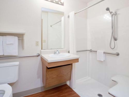 uma casa de banho branca com um lavatório e um chuveiro em WoodSpring Suites Grand Junction em Grand Junction
