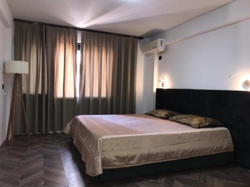 a bedroom with a bed and a large window at Hotel Lido in Durrës