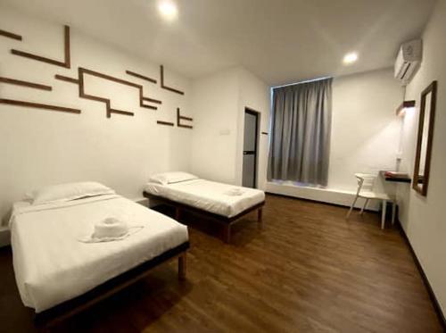 a room with two beds and a sink in it at Kuching Hotel in Kuching