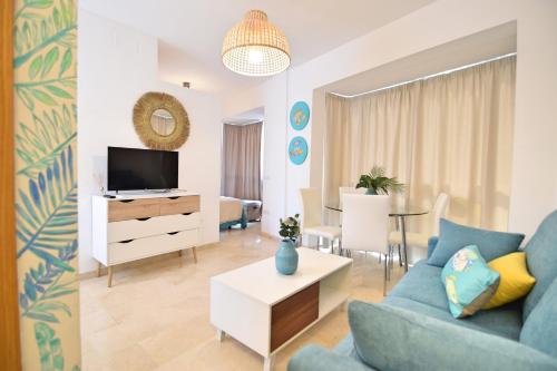 sala de estar con sofá azul y TV en Bonito apartamento a 5min.  del centro histórico, en Málaga