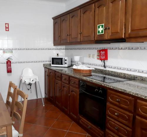 una cucina con mobili in legno e un piano di lavoro di Monte Vistoso - Duna Parque Resorts & Hotels a Vila Nova de Milfontes