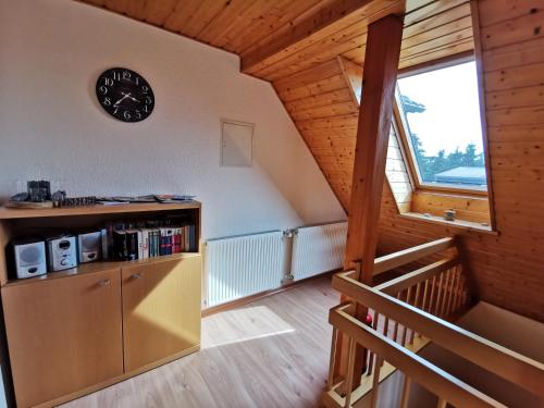 a kitchen with a clock on the wall and a staircase at Dorfidyll Wendisch Priborn in Wendisch Priborn