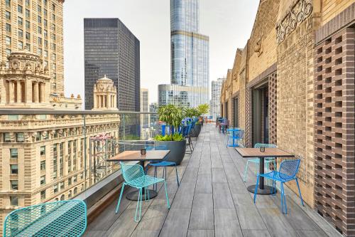 a balcony with tables and chairs and a city skyline at Virgin Hotels Chicago in Chicago