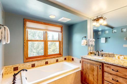 bagno con vasca e finestra di Torian Plum Plaza 401 a Steamboat Springs