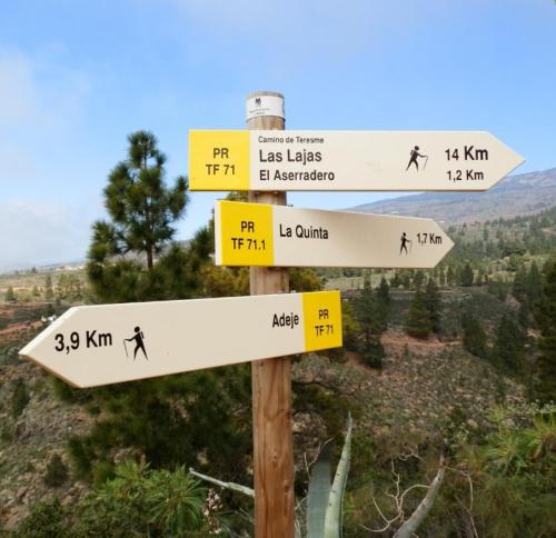 a street sign with arrows on a mountain at CASA rural DOLORES en Adeje in Adeje