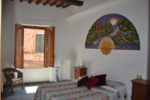 - une chambre avec un lit et une peinture murale dans l'établissement Palazzo Bufalari appartamento in centro storico, à Città della Pieve