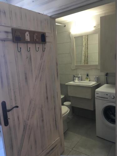 a bathroom with a toilet and a sink and a door at Elata Stone House in Eláta