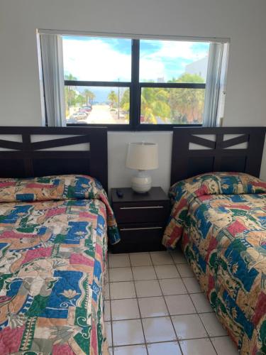 een slaapkamer met 2 bedden en een raam bij Napoli Belmar Resort in Fort Lauderdale