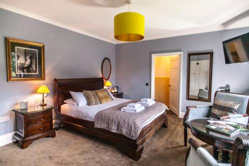 a bedroom with a bed and a table and a chair at Port Lympne Mansion Hotel in Hythe