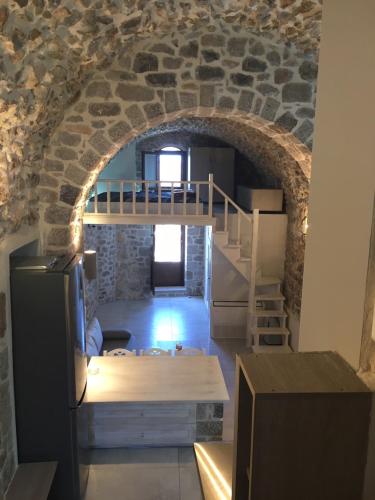 a room with a stone wall and a room with a refrigerator at Elata Stone House in Eláta